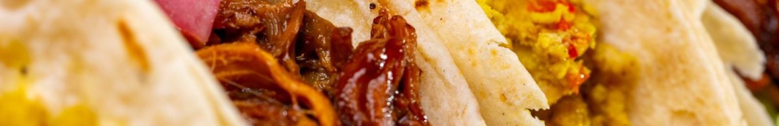 A close-up of appetizing tacos filled with flavorful meat and vegetables.